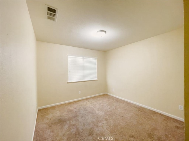 carpeted spare room featuring baseboards and visible vents