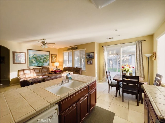 kitchen with tile counters, open floor plan, and a sink