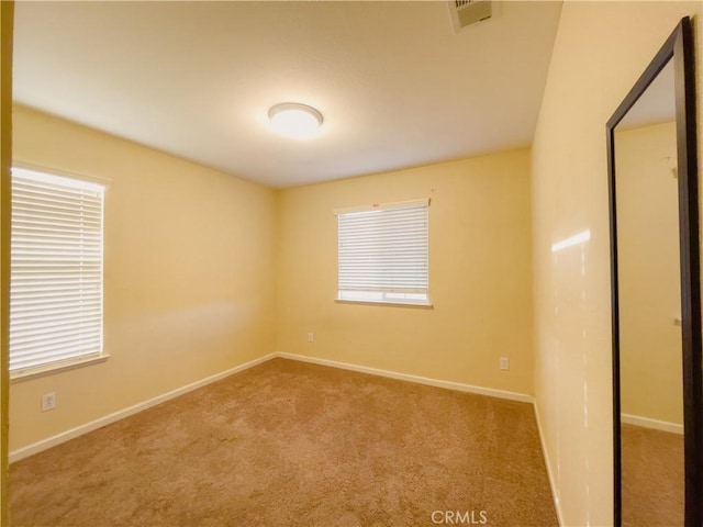 carpeted empty room with baseboards and visible vents