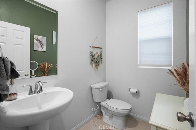 bathroom with sink, toilet, and tile patterned flooring