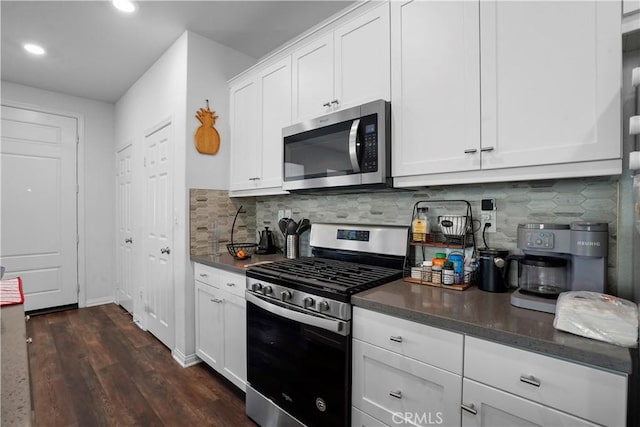 kitchen with stainless steel appliances, backsplash, and white cabinetry