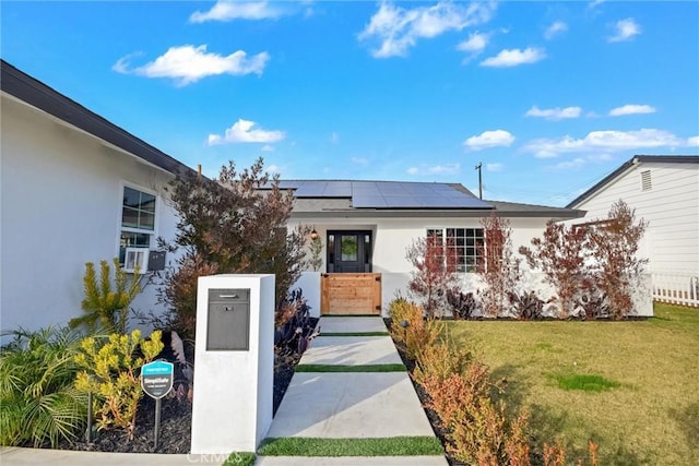 doorway to property with a lawn and solar panels