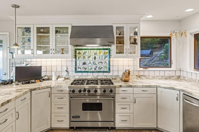 kitchen with stainless steel appliances, pendant lighting, white cabinetry, and wall chimney range hood