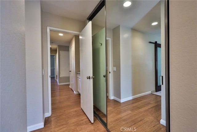 hall featuring a barn door and light wood-type flooring