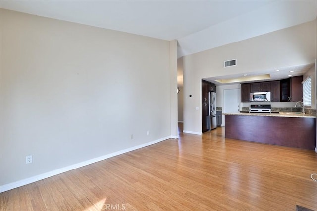 unfurnished living room with light hardwood / wood-style floors and sink