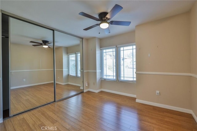 unfurnished bedroom with a closet, light hardwood / wood-style floors, and ceiling fan