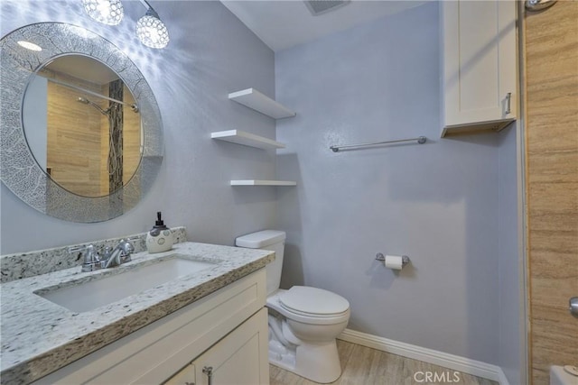 bathroom featuring wood-type flooring, toilet, vanity, and walk in shower