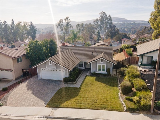 view of front of property with a front lawn, a garage, and a mountain view