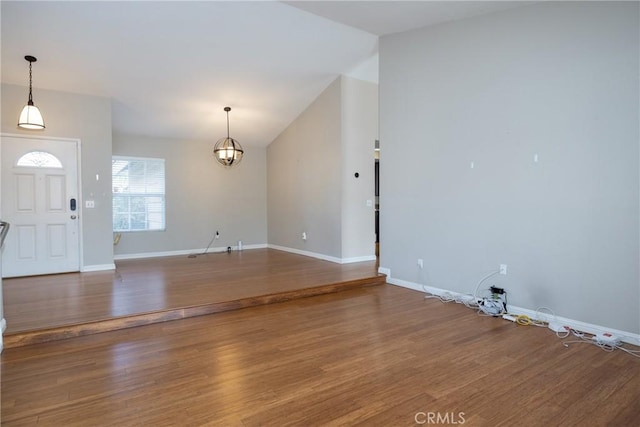 entrance foyer with vaulted ceiling, a chandelier, and hardwood / wood-style floors