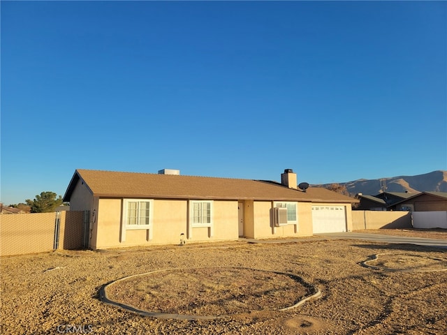 back of house with a mountain view and a garage