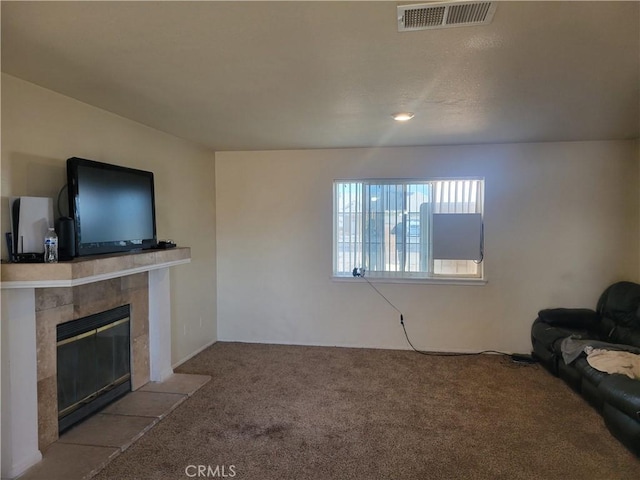 unfurnished living room featuring light colored carpet and a tile fireplace