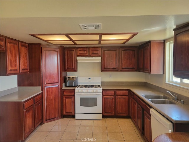 kitchen with visible vents, under cabinet range hood, a sink, white appliances, and light tile patterned floors