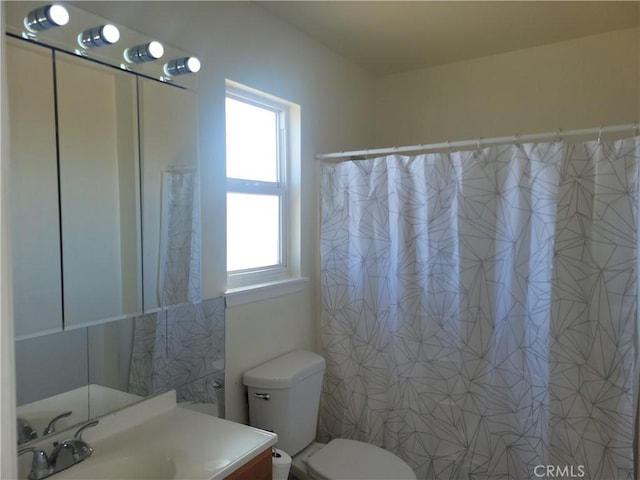 bathroom featuring plenty of natural light, toilet, and vanity