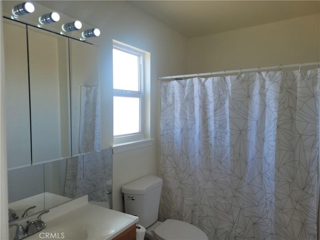 full bath featuring toilet, vanity, and a shower with curtain