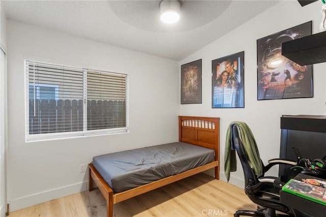 bedroom with ceiling fan, lofted ceiling, and hardwood / wood-style flooring