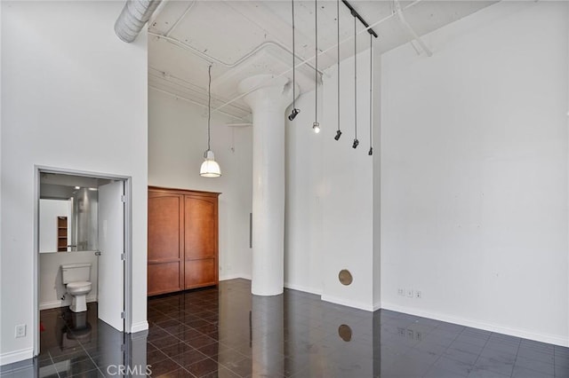 interior space featuring toilet, tile patterned flooring, and a high ceiling