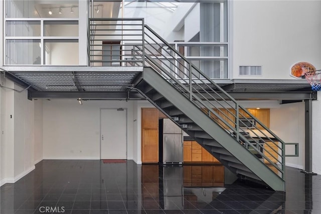 stairs featuring tile patterned flooring and a high ceiling