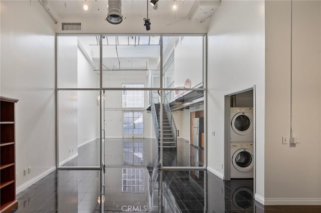 laundry area featuring stacked washer / drying machine