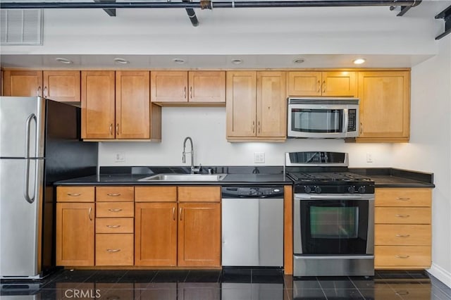 kitchen with sink, stainless steel appliances, and dark tile patterned floors