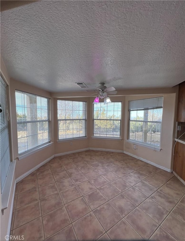 unfurnished sunroom featuring ceiling fan