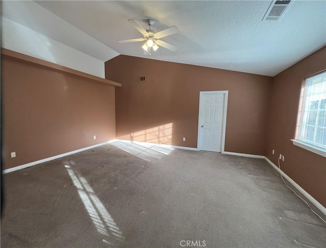 interior space with carpet floors, vaulted ceiling, a textured ceiling, and ceiling fan