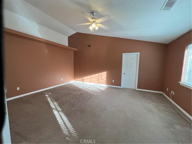 carpeted empty room featuring ceiling fan, a textured ceiling, and vaulted ceiling