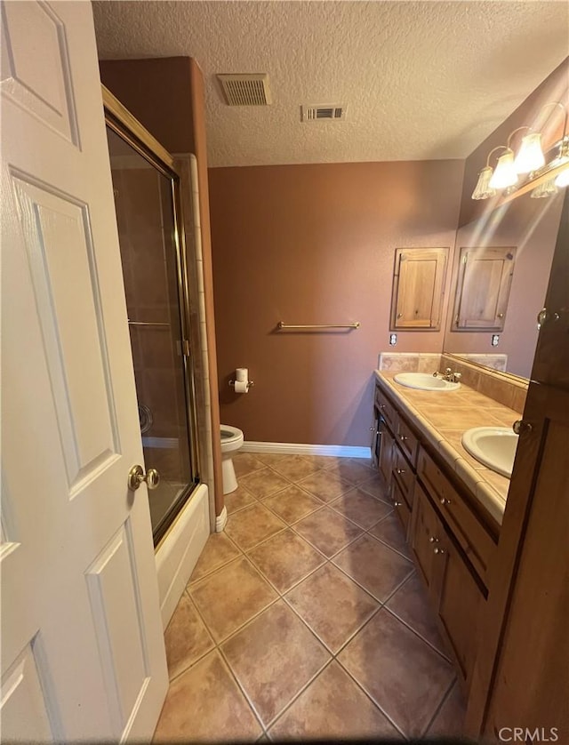 full bathroom featuring toilet, tile patterned floors, a textured ceiling, vanity, and shower / bath combination with glass door