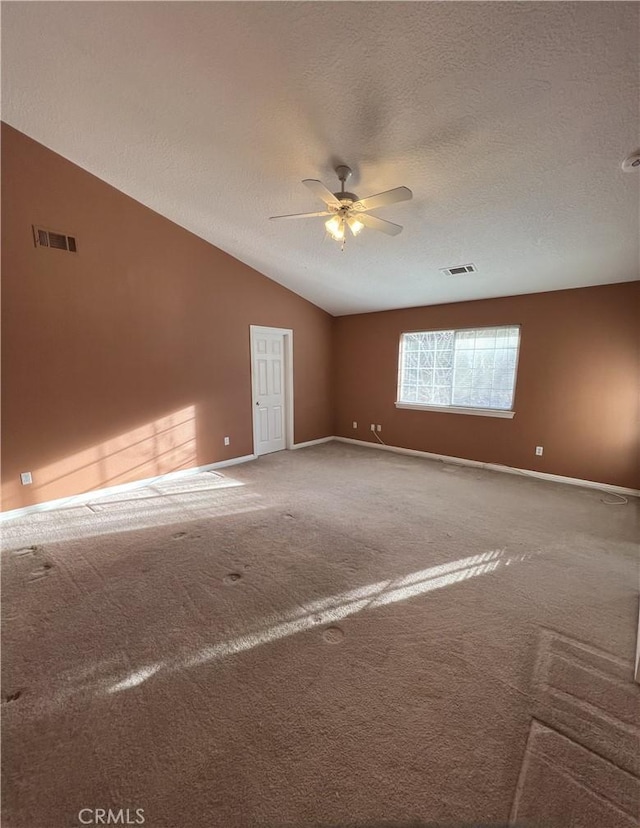 carpeted empty room featuring ceiling fan, a textured ceiling, and vaulted ceiling