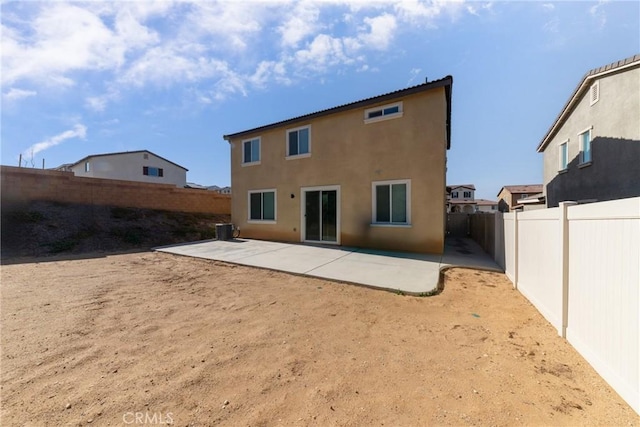 rear view of property with central AC unit and a patio