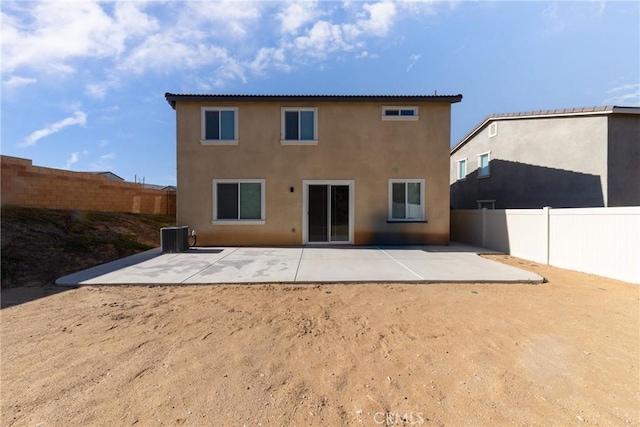 rear view of property with cooling unit and a patio