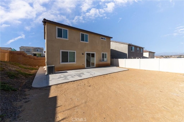 rear view of property with central AC unit and a patio