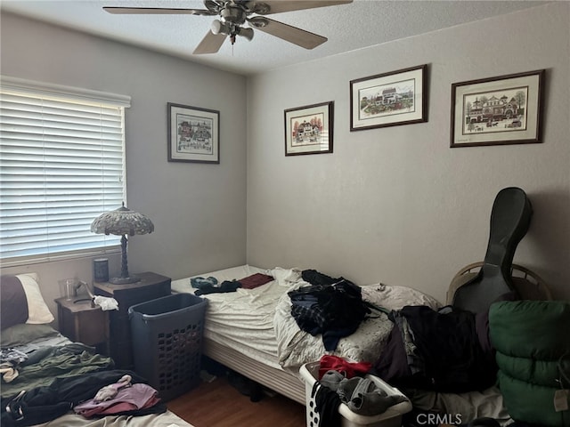 bedroom featuring hardwood / wood-style flooring, a textured ceiling, and ceiling fan