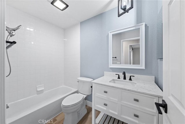 bathroom featuring washtub / shower combination, vanity, wood finished floors, and toilet