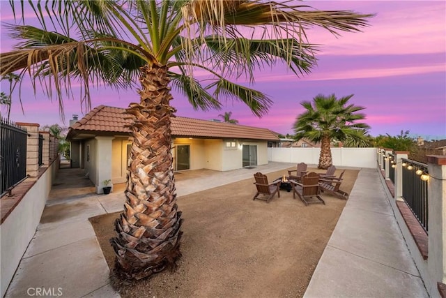 patio terrace at dusk featuring fence