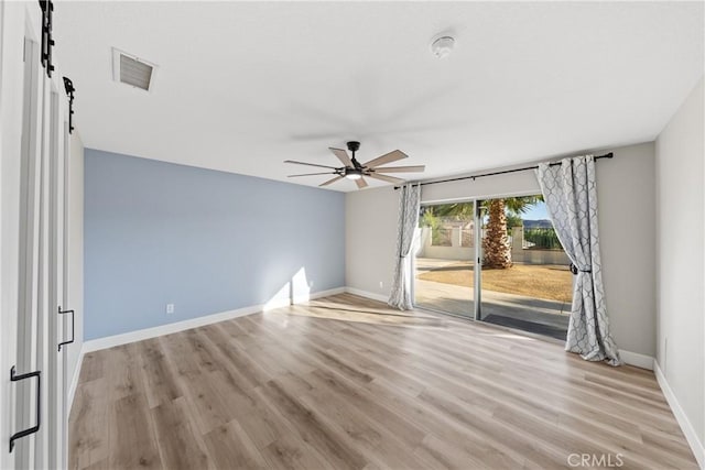 spare room with light wood-type flooring, baseboards, visible vents, and a ceiling fan