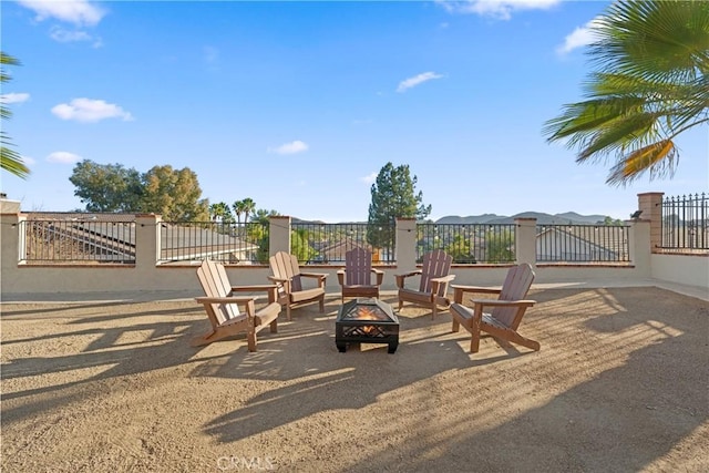 view of jungle gym featuring fence, a fire pit, and a mountain view