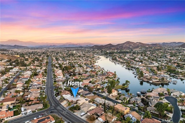 aerial view at dusk featuring a residential view and a water and mountain view