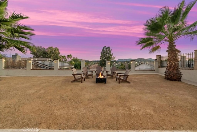 view of yard with a fire pit, a gate, and fence