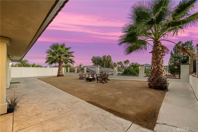 yard at dusk with a patio area and a fenced backyard