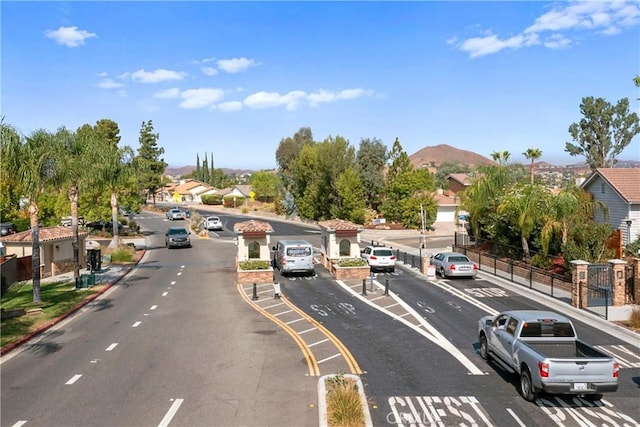 view of street with sidewalks, a residential view, a mountain view, and curbs