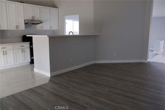 kitchen with light tile patterned flooring, white cabinetry, and kitchen peninsula