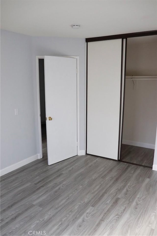 unfurnished bedroom with light hardwood / wood-style floors and a closet