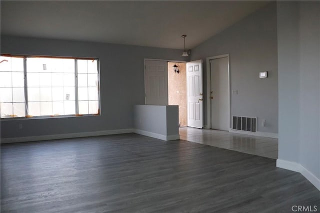 unfurnished room with vaulted ceiling and dark hardwood / wood-style floors