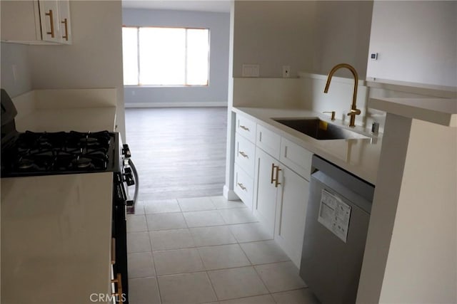 kitchen featuring black gas range, dishwasher, white cabinets, and sink