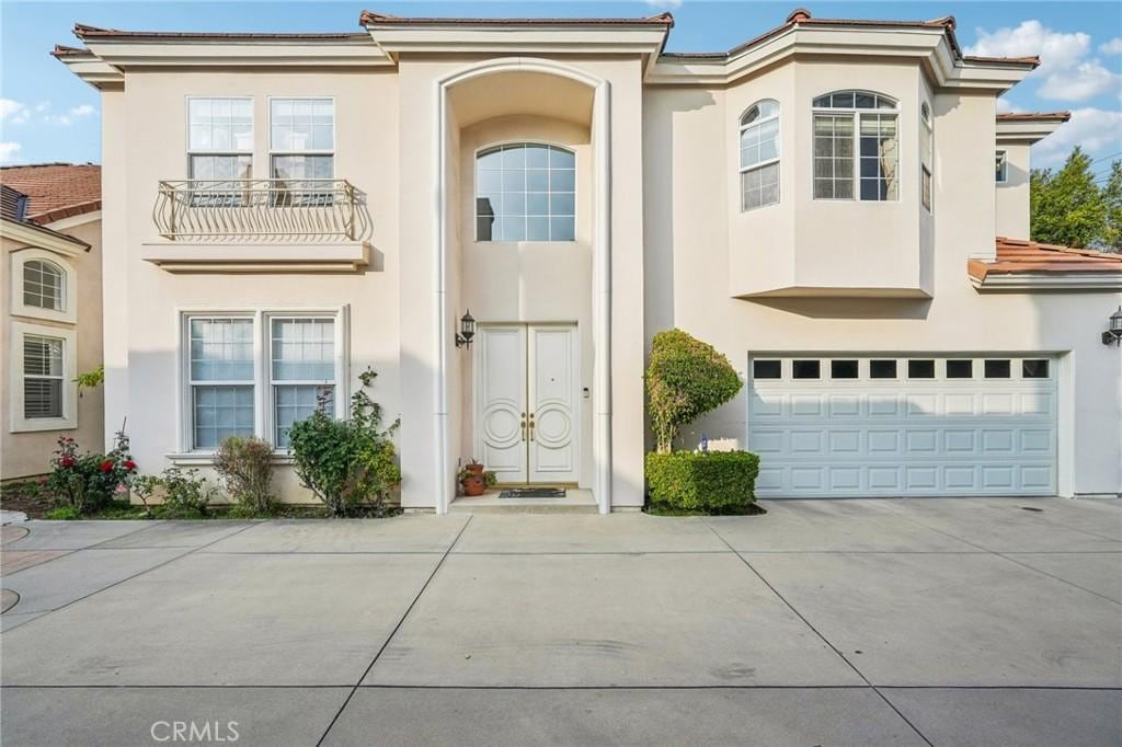 mediterranean / spanish-style house featuring stucco siding, driveway, and an attached garage