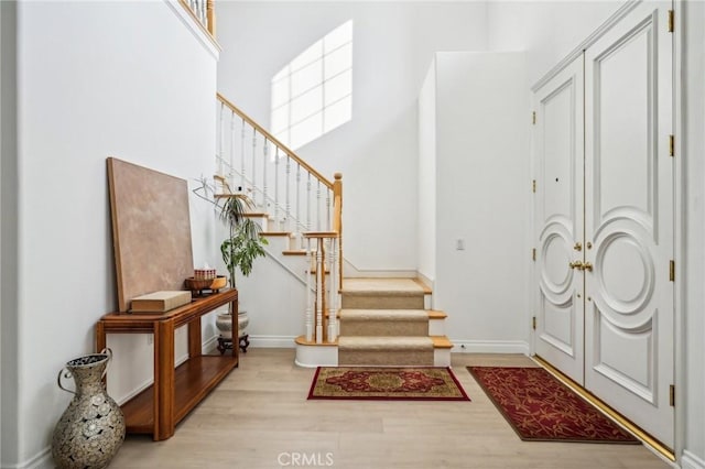 foyer with light hardwood / wood-style flooring and a high ceiling