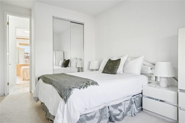 bedroom with a closet and light colored carpet