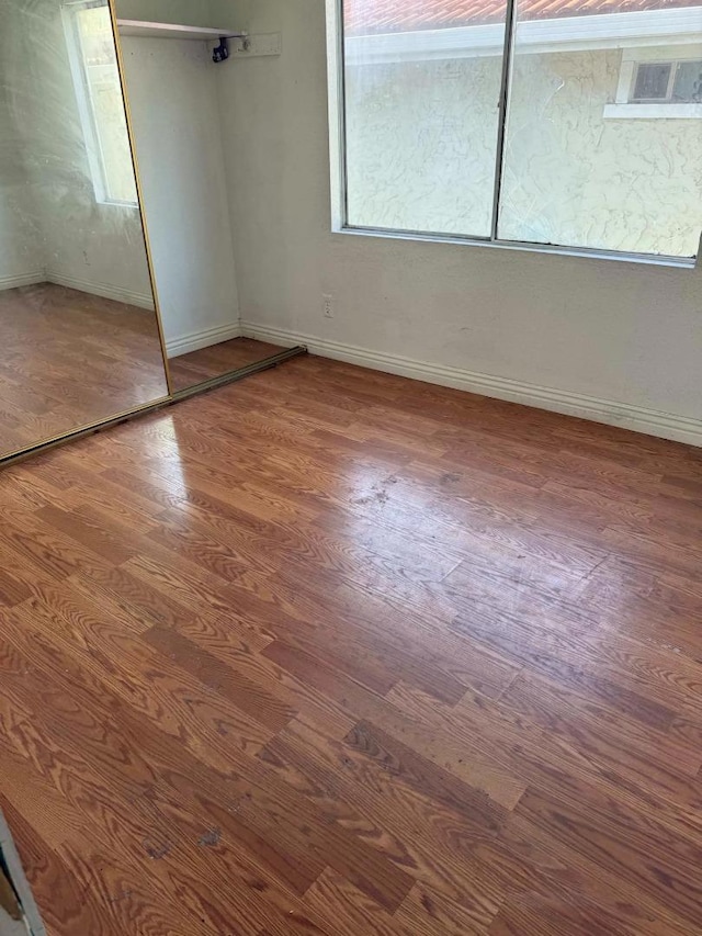 unfurnished bedroom with wood-type flooring and a closet