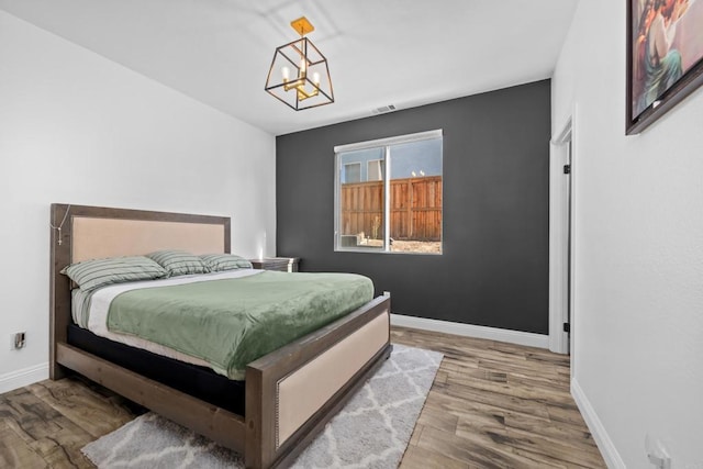 bedroom featuring a chandelier and wood-type flooring