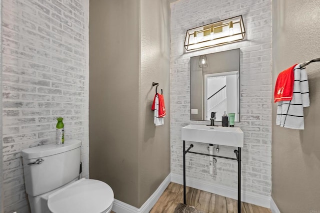 bathroom featuring toilet, sink, and hardwood / wood-style floors